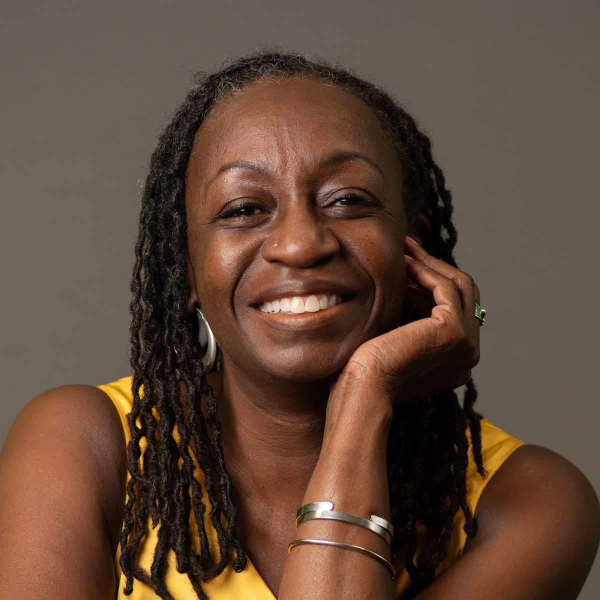 Dr. Wendy Shaia smiling, chin resting on her hand, wearing a yellow top